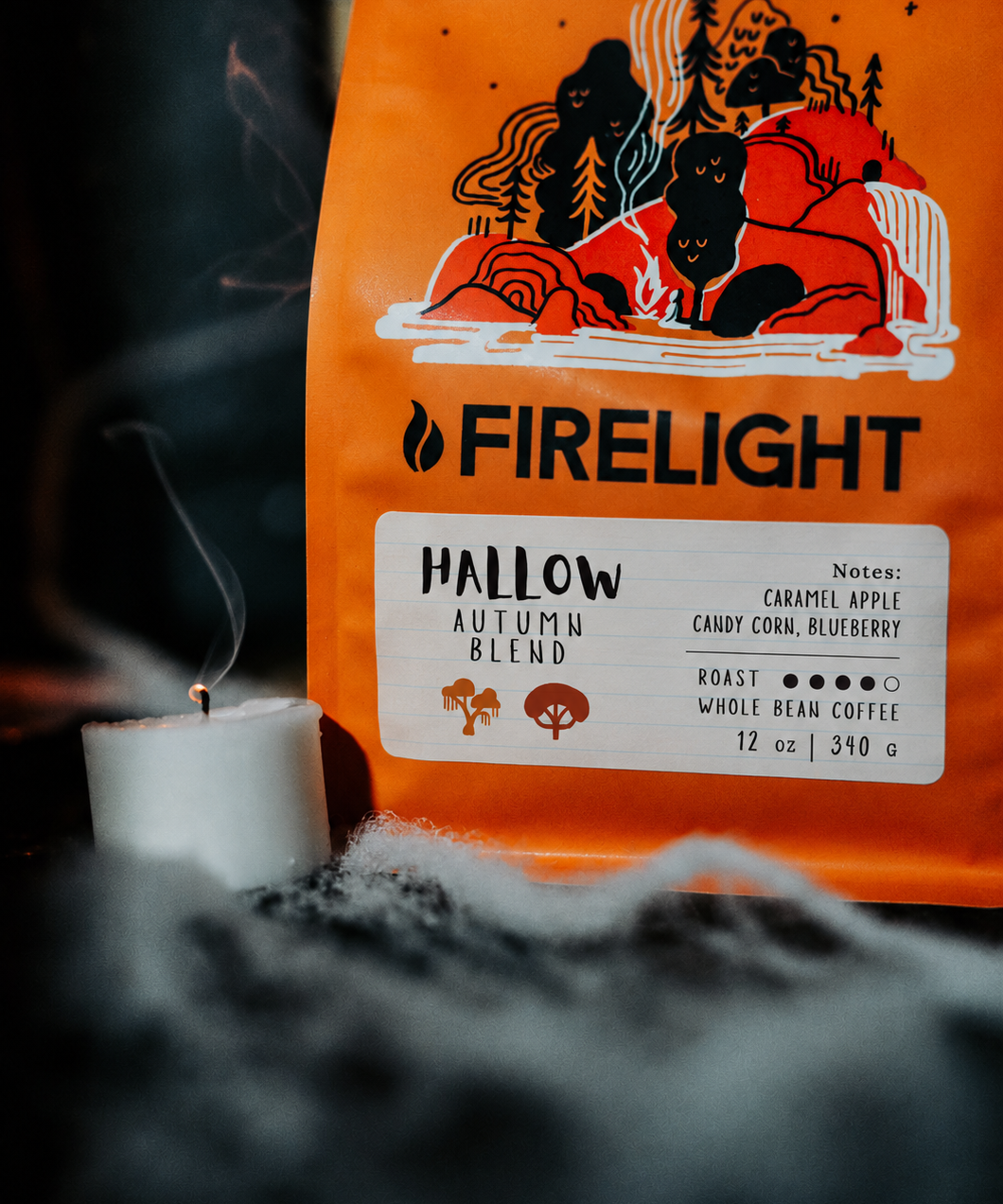 Hallow Autumn Blend bag beside a lit candle